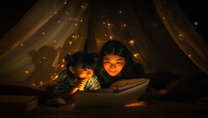 Mom reading a book to daughter 